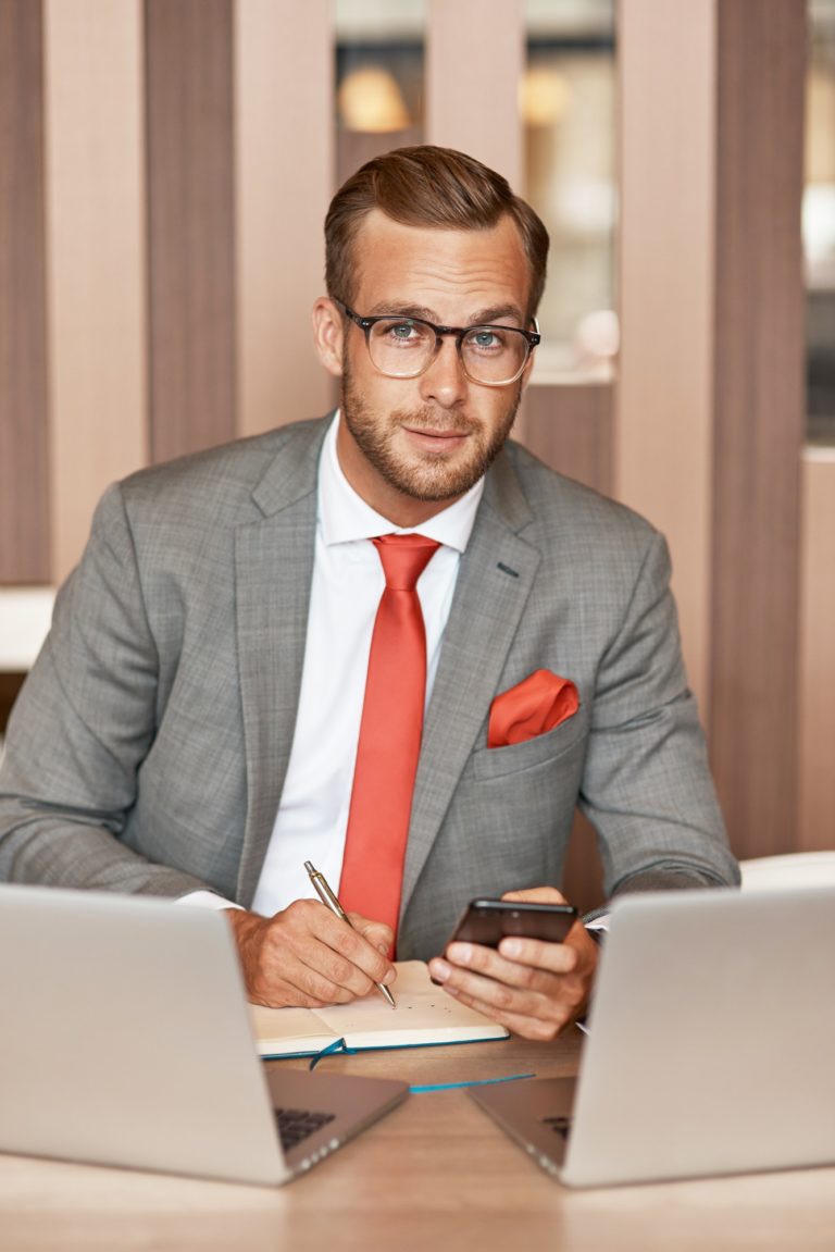 Positive young businessman sitting in the office